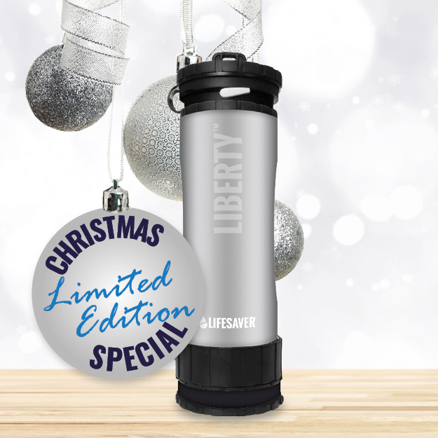 Load image into Gallery viewer, Silver Liberty on a wooden surface, surrounded by Christmas ornaments.
